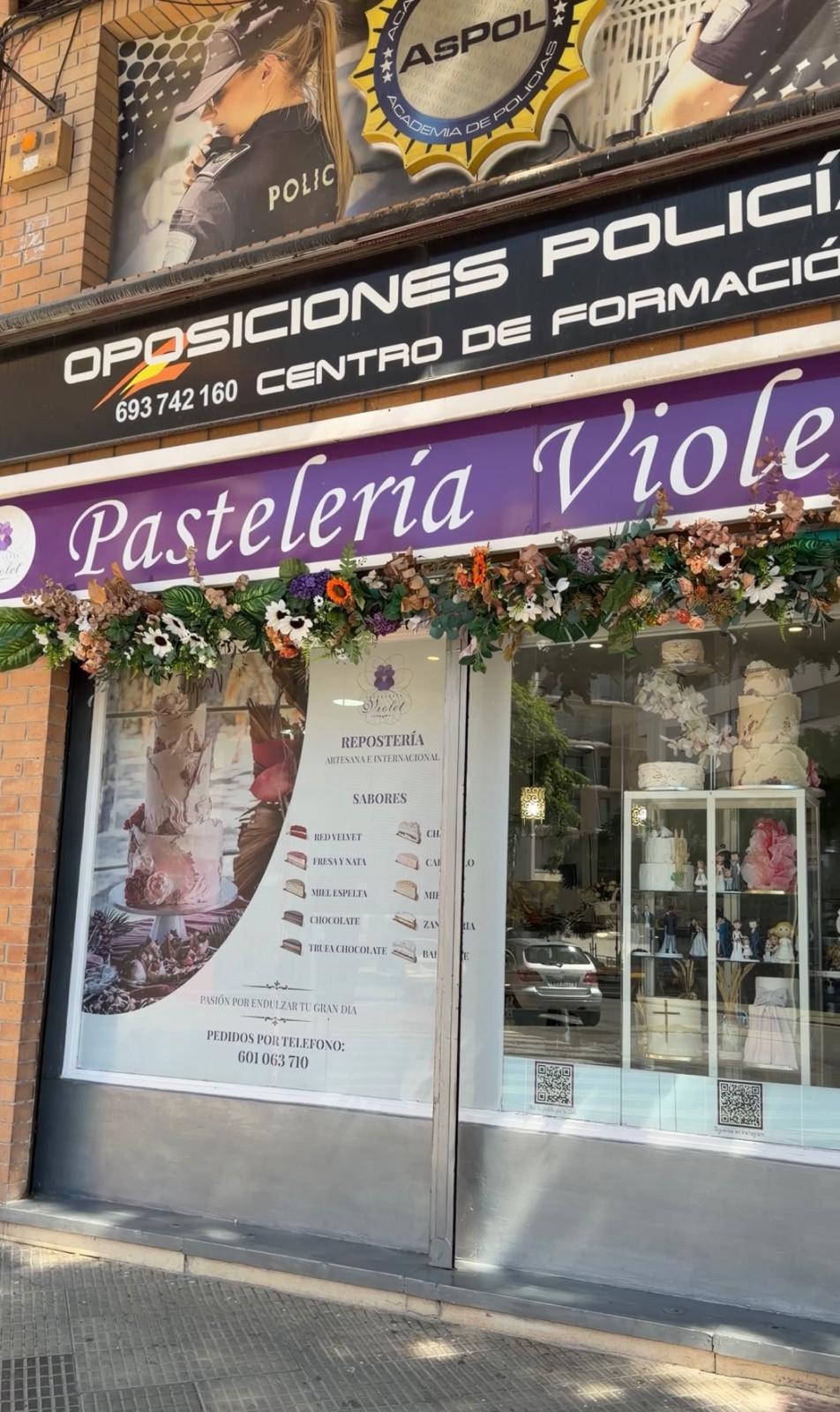 Entrada de Pastelería Violet, con su rótulo violeta y decoración floral